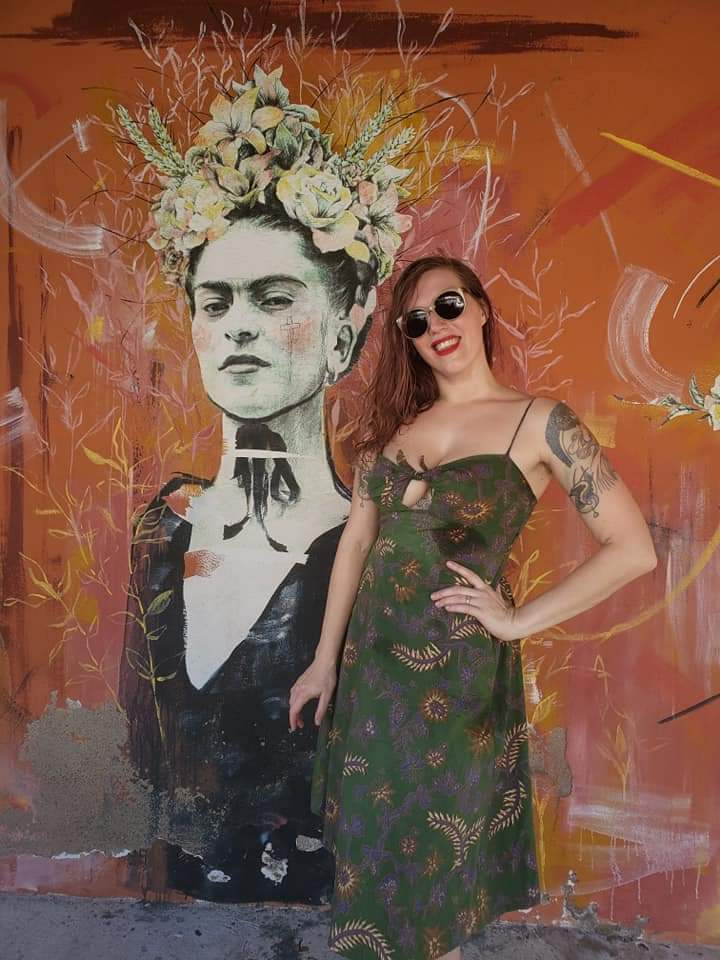 Holly standing in front of a portrait of Frida Kahlo painted in Zihuatenejo, Mexico
